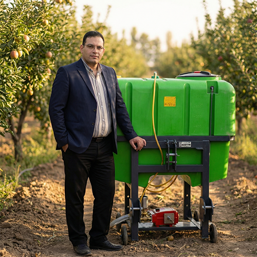 مدیر فروشگاه غیاثی به همراه سمپاش پشت تراکتوری در باغ